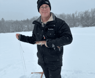 Maine Guided Ice Fishing Trips client holding a large Northern Pike