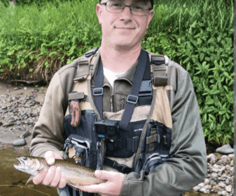 Angler wading a Maine river fly fishing for trout