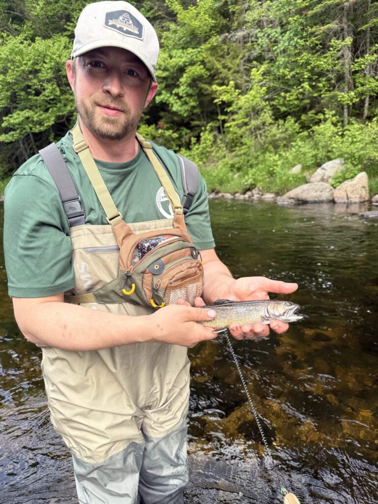 Registered Maine Guide holding a landlocked salmon while wade fishing