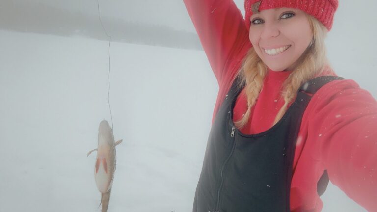 Angler on a frozen Maine lake with a fish caught through the ice