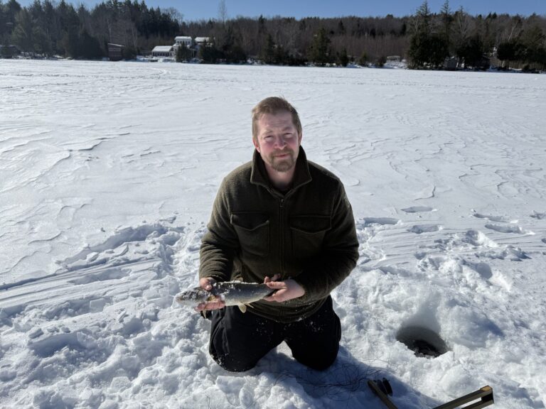 Angler with a chain pickerel caught through the ice in Maine