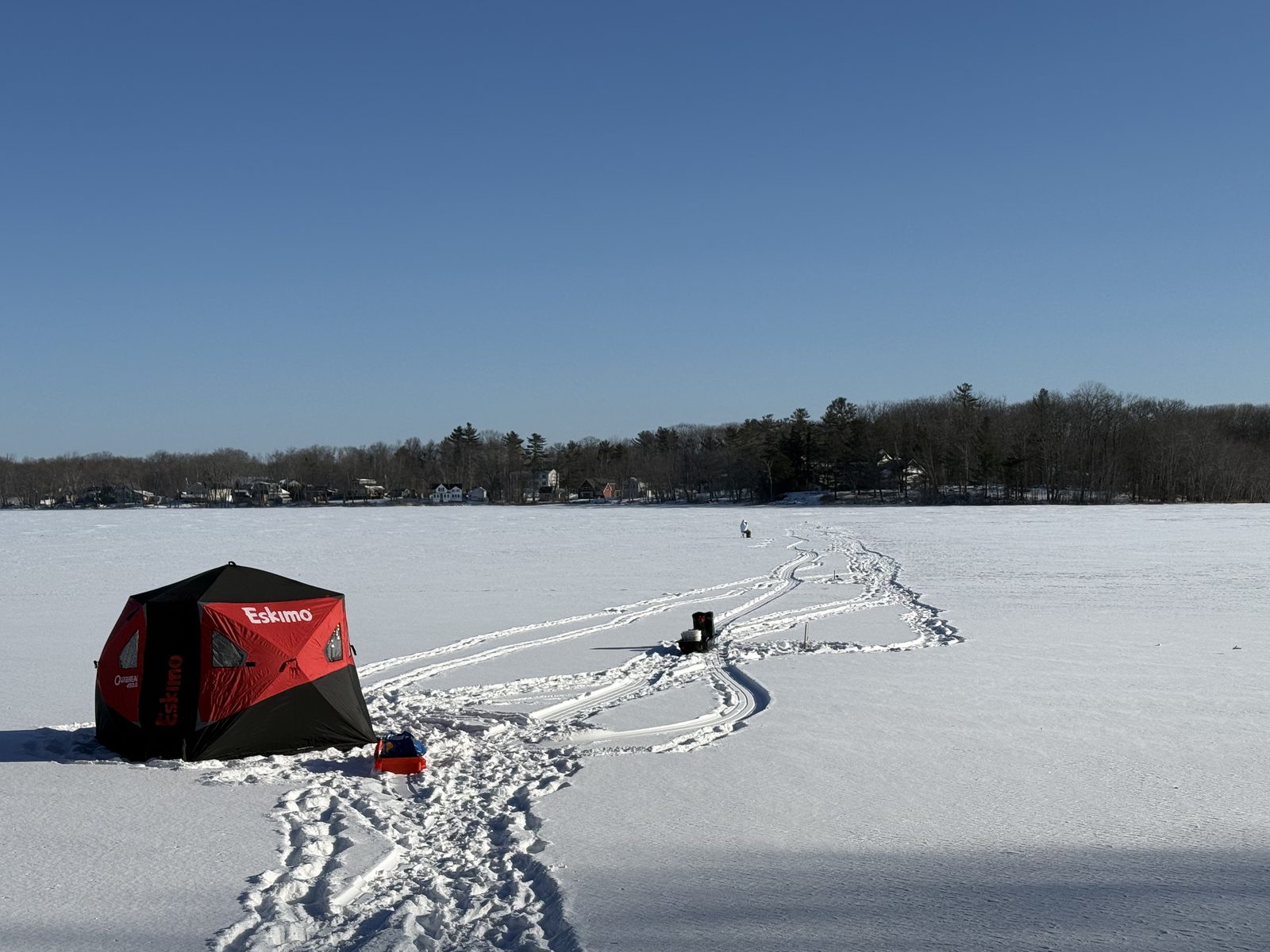An ice fishing shelter set up on a frozen Maine lake